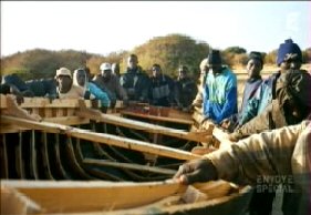 Kingsley et ses compres en train de monter une pirogue